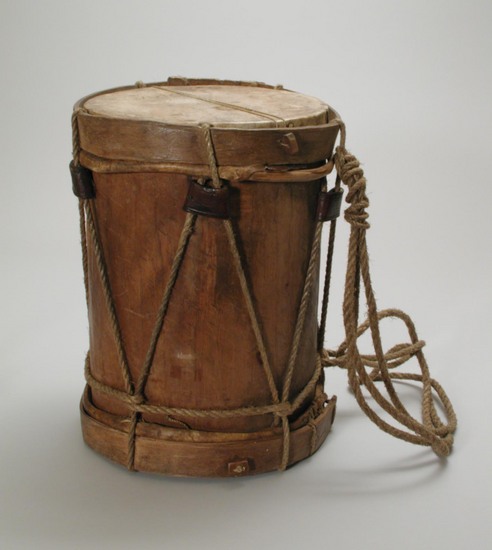 Hearst Museum object titled Drum and sticks, accession number 3-16475a-c, described as (a) double-headed drum; skin head on each end; wooden body; tension maintained by ropes around outside; 35 cm. hi., 26 cm. dia.; (b-c) wood drusticks, ea. 30 cm. long Used for what purpose(s): musical accompaniment; usually complemented by 'pito' How used: slung over one shoulder; single-head played at one time; leather sleeves on side lacing used to tighten drum heads.  relaxed when not in use; vibrator strings across heads tightened when in use to give resonance By whom used (e.g., men or women): part-time professional male tambor players Made of what materials: wooden trunk of Cedrela mexicana Roem.  drum head made of skin of a sheep.  lacing and suspension cords of sisal Made by (e.g., men or women): men only, usually by tambor players, but it does not appear that all tambor players make their own tambores Remarks: this specimen made by Juan Cruz Rodriguez; the drum about one year old.  price paid: $30. MN