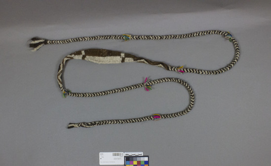 Hearst Museum object titled Sling, accession number 16-8550, described as Sling; black, brown and white braided, 204 cm long, with multi-colored short fringes on both sides of sling; pouch is 1/2 brown and 1/2 white with zig zag design braid pattern