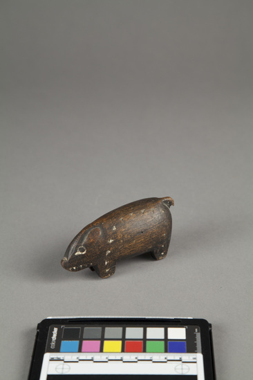 Hearst Museum object titled Carving of pig, wood, incised, accession number 11-42726, described as Carving of pig, wood, black with white incisions. length - 10.6 cm., height - 5.0 cm.