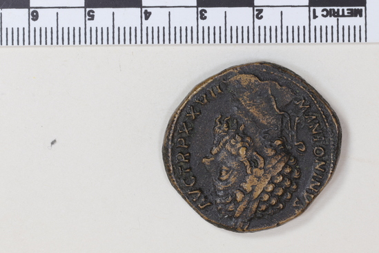 Hearst Museum object 6 of 8 titled Coin: æ sestertius, accession number 8-5521, described as Coin; AE; Sestertius; Roman. 25.82 grams, 31.5 mm. Marcus Aurelius Antoninus, 172-173 AD. Rome, Italy. Obverse: M ANTONINUS AUG TR P XXVII, bust r. laureate. Reverse: JIMP VI COS III, upiter, naked to waist, seated facing l. on throne, holding Victory and scepter; in exergue, SC.