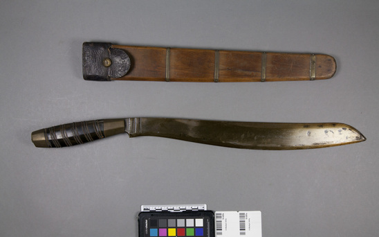 Hearst Museum object 2 of 2 titled Knife and sheath, accession number 10-695a,b, described as a) Two edged bolo, handle black horn inlaid with brass wire. b) Sheath wood, 4 strips of brass and one of leather.