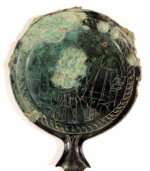 Hearst Museum object 13 of 13 titled Stemmed mirror, accession number 8-5859, described as Etruscan bronze mirror; cast-handle type; encrustation on both surfaces of disk and blue discoloration on obverse due to bronze disease; dark green patina; handle ends in stylized ram’s head; rim of obverse beaded; engraved scene of four figures, two women flanking Minerva (Greek=Athena) and nude man, standing against architecture; guilloche border; mirror appears to have been conserved with a translucent glaze.