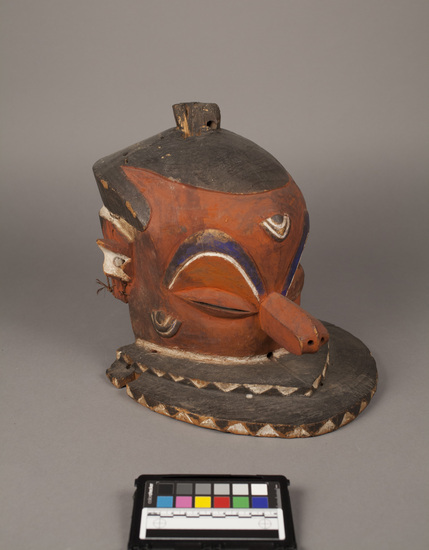 Hearst Museum object titled Mask, accession number 5-6239, described as Mask; wood helmet; drum-shaped head; perforated knob on top; snout nose; double horizonatal round shelf below nowse; slit eyes.H = 30.0cm.