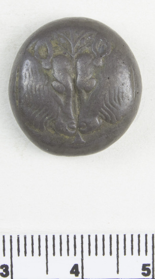 Hearst Museum object 6 of 6 titled Coin: billon stater, accession number 8-5574, described as Coin; Billon; stater; Greek. 10.75 grams, 18.6 mm. 550-440 BC. Myilene, Greece. Obverse: two calves’ heads confronted, between them olive-tree. Reverse: rude incuse square.