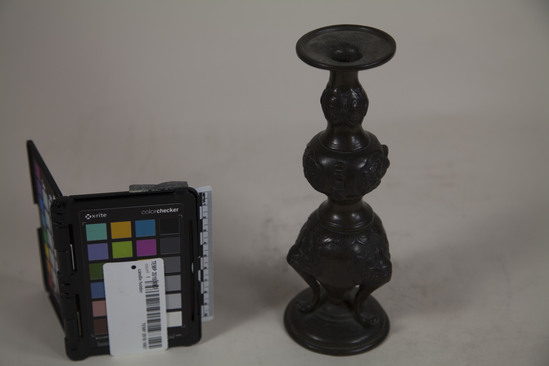 Hearst Museum object titled Candle holder, accession number TEMP 2018.1067, described as candle holder with faces on base and carving on top