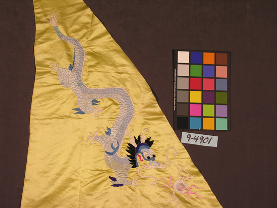 Hearst Museum object titled Textile, accession number 9-4901, described as Textile fragment, yellow silk, embroidered with dragon; scales in shades of blue; triangular in shape; w. 142 cm.