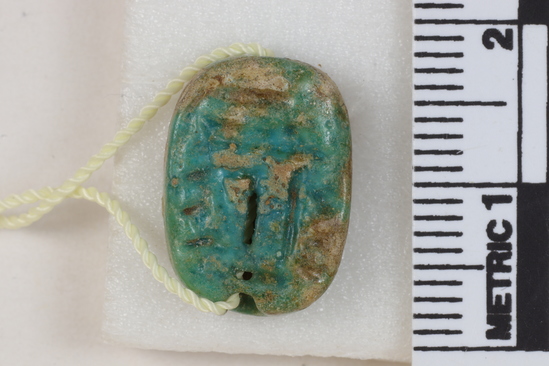 Hearst Museum object 15 of 19 titled Amulet, accession number 6-8801, described as Oval plate amulet, blue glaze partly gone