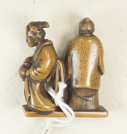 Hearst Museum object titled Netsuke, accession number 9-18832, described as Netsuke; man and woman (couple), standing together, her back to his left side; he carries fan in right hand, she carries langern in her right hand; no cord tunnel; rectangular base; H 4.1 cm X W 3.5 cm