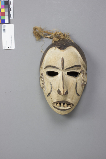 Hearst Museum object titled Wooden mask, accession number 5-3808, described as Anthropomorphic wooden face mask, white ground with black features; cordage tie string. Height 22.5 cm.