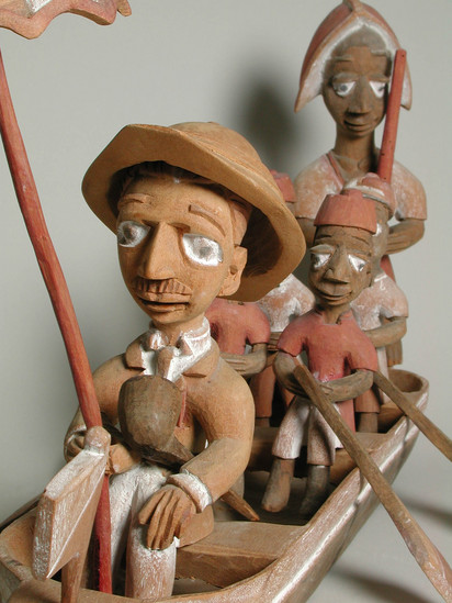 Hearst Museum object 12 of 15 titled Figures, accession number 5-16237a-q, described as caricature figure group; caricature of a District Officer on tour; carved & painted wood a - boat, has bag of frags b - Dist. officer (front) c - poler (rear) d - paddler (LF) e - paddler (LR) f - paddler (RF) g - paddler (RR) h - hat i - umbrella handle j - umbrella k - flag l - pipe m - pole n - paddle (RF) o - paddle (LF) p - paddle (LR) q - paddle (RR) Found two pegs in a bag with this object number.