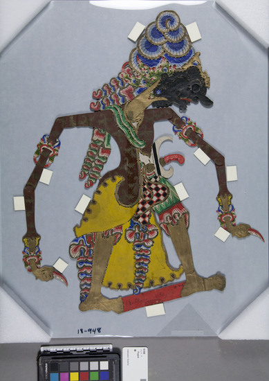 Hearst Museum object titled Shadow puppet, accession number 18-948, described as shadow puppet; depicts Lord Bhima, one of the Pandawa brothers of the Mahabharata; cardboard, sized and painted various colors; small decorative cutouts; no mounting on stick as is usual with this figures; arms move; used as puppet in wajang kulit performances; held in front of light, behind screen, moved