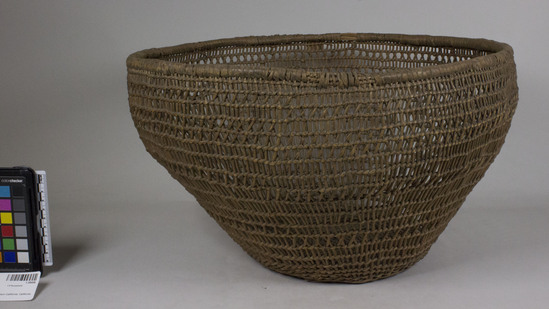 Hearst Museum object 2 of 2 titled Bowl basket, accession number 1-28458, described as Openwork twined, bowl-shaped.  Tag "Klamath R. Tribes Att." Per Ralph Shanks:  Openwork twined basket. The basket has two pairs of crossed warps at the starting knot.  The warp material is probably hazel.  The wefts are also possibly hazel.  At the rim is a bundle of reinforcing sticks wrapped with probably wild grape.  At the base there is plain twining to the edge, where there are two weft rows of three strand twining.  Plain twining then continues to the rim.  The warp sticks are crossed at five rows throughout the basket.  At the rim the basket has two closer spaced rows of weft. The basket has an up to the right slant of weft twist.  The basket has a rightward work direction with an exterior workface.  The basket is from Northwestern California.