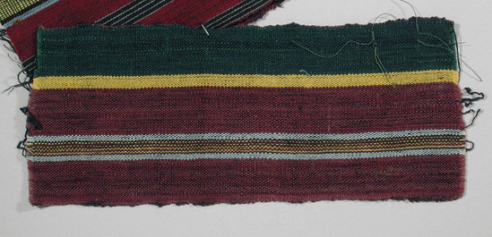 Hearst Museum object titled Textile fragment, accession number 5-11252, described as textile sample (section of narrow band weaving): 2/3 deep rose, rose divided by stripe of pale blue, yellow, rose and black, also green stripes showing navy blue, and narrow yellow stripe.