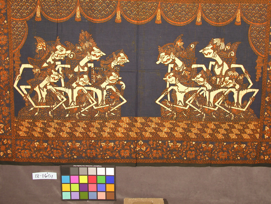 Hearst Museum object titled Wall hanging, accession number 18-1601, described as Wall hanging; brown, blue, black and beige; “wayang kulit” (shadow puppet) theater scene; two groups of figures sitting on stage with draped curtains above; wide bands of floral designs surround stage on four sides; two raw cloth edges; numerous small holes at top corners from hanging. 100.5 x 159 cm.