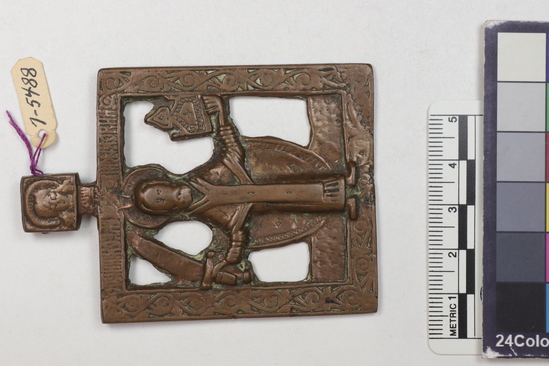 Hearst Museum object titled Icon, accession number 7-5488, described as Icon; metal; representing St. Nicholas of Mozhaysk; he holds a sword in his right hand and a church in his left; height 8 cm, width 5.8 cm. Cost $5.00.