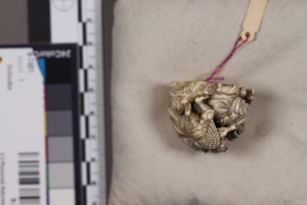 Hearst Museum object 5 of 6 titled Netsuke, accession number 9-7492, described as Netsuke: crowd of beasts with beaks (Tengu) of birds and wings. Principal figure, wearing armor, helmet and club, is female.