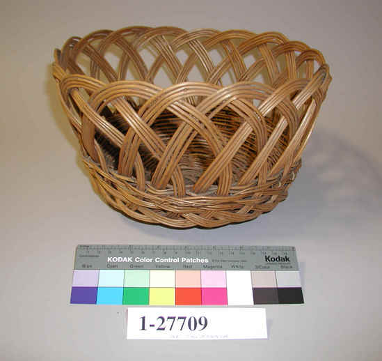 Hearst Museum object titled Basket, accession number 1-27709, described as Round, flat base. Sides formed by open loops becoming closed at base, cotton string woven in near base. Wicker.