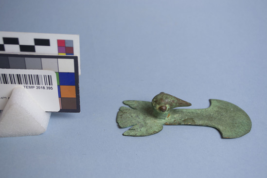 Hearst Museum object 4 of 4 titled Tumi, accession number TEMP 2018.395, described as Green metal tumi with bird handle; three-dimensional bird head extends from handle; either copper or bronze.