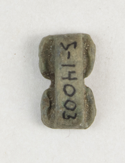 Hearst Museum object 2 of 6 titled Amulet, accession number 5-14003, described as Amulet: hourglass shaped with raised squares on front. Greenish brown with hole through back.