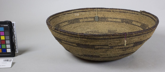 Hearst Museum object 2 of 2 titled Cooking basket, accession number 1-11961, described as Hemispherical coiled basket.  Tag "Yuki". Per Ralph Shanks:  Wide- mouthed coiled basket bowl, the same shape and size as a typical Yuki cooking bowl.  It has food residue in it but no evidence of cooking, it could have been used as a sifter.  The basket has a pinhole start.  The coil foundation is mixed rods and splints.  The wefts are peeled and unpeeled redbud.  The design is six horizontal bands with varying widths, a few with open and closed rectangles.    The rim is plain wrapped.  The coil ending is broken, but several herringbone stitches are left.  The weft fag ends are a mixture of clipped and concealed.  The weft moving ends are concealed.  The workface has a few split stitches; the back face has up to 80% split stitches.  The basket has an exterior workface, with a rightward work direction, and a primarily down to the right slant of weft twist.