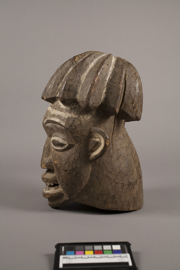 Hearst Museum object titled Wooden mask, accession number 5-5994, described as Female helmet mask of carved wood with white pigment on face and features; carved elaborate ridged hair style; h. 37 cm.