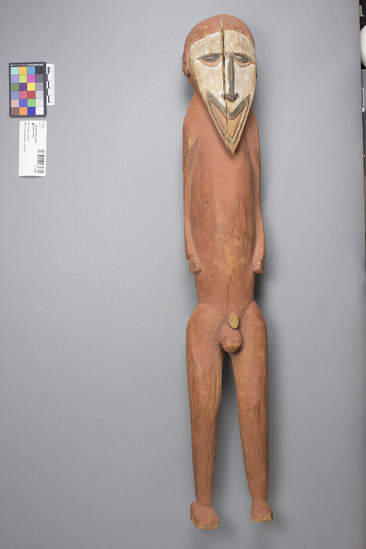 Hearst Museum object titled Wood human figure, painted, male, accession number 11-1635.1, described as Ancestor figure, male, carved wood painted red w/ black and white facial features; split in middle of face, penis broke off.