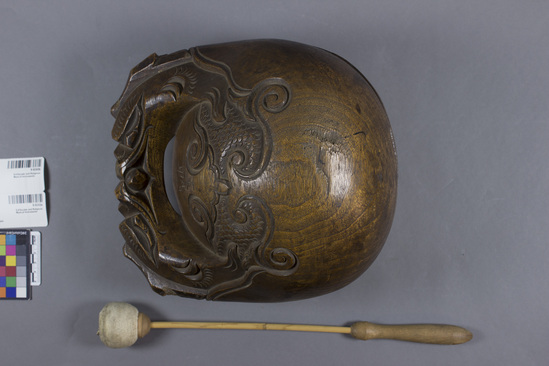 Hearst Museum object titled Ball on a stick, accession number 9-9243a,b, described as Drum;w/drumstick (a)ovoid hollow decoratively carved wood; L. 25 cm.(b) long plain wood drumstick w/stuffed leather ball on end;L.39 cm.