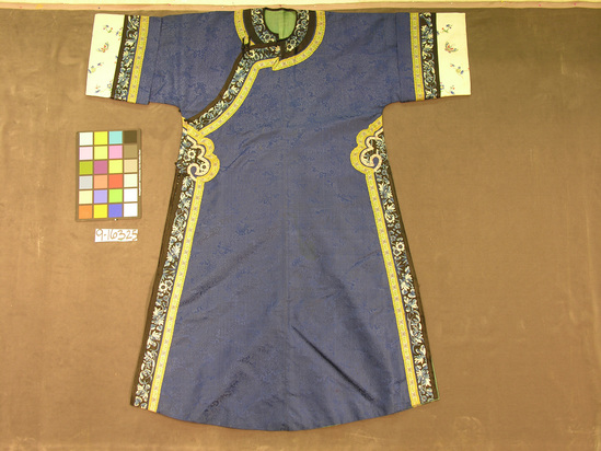 Hearst Museum object titled Robe, accession number 9-16325, described as Robe, blue silk damask lined in green silk. Band, embroidered in blue and white floral pattern, runs along sides, around neck and sleeves. White satin sleeve borders embroidered in butterfly and floral patterns. 5 frog right side closure. Length 36 cm.