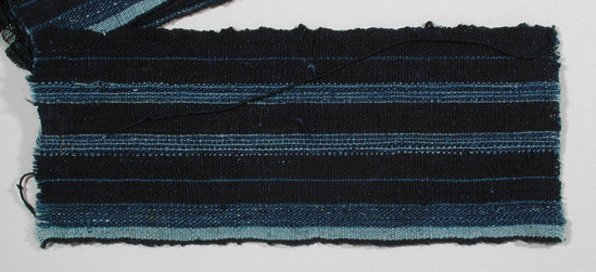 Hearst Museum object titled Textile fragment, accession number 5-11133, described as Textile sample (section of narrow band weaving): cotton; navy ground; two stripes alternating light and medium blue; two stripes blue; one edge, one band of medium blue and one band of light blue.