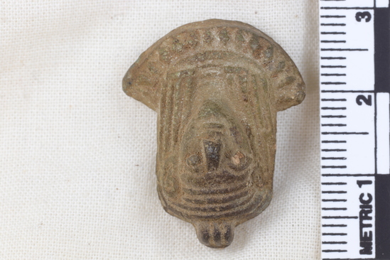 Hearst Museum object 6 of 11 titled Amulet, accession number 5-13917, described as Amulet: anthropomorphic with beadwork collar, long straight hair, bulging eyes, and ears high on head. No holes for stringing amulet. Maybe a fake. Fingerprint on back. Height 2.7 cm.