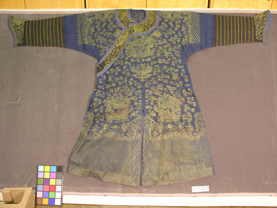 Hearst Museum object titled Robe, accession number 9-17967, described as Robe: dark blue silk patterned w/ yellow silk embroidery in usual cosmological symbols (dragon, mountains & waters, clouds, bats, etc. some Buddhist symbols) open at sides; sleeve cuffs, neck trim & body trim all match; horsehoof sleeve black silk mesh, neck trimmed w/ woven braid & trim metallic braid; loop & toggle closure.  Man's tunic (summer court wear); relatively rare; c. 1800s.  138.8 cm L.