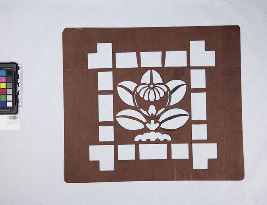 Hearst Museum object titled Stencil, accession number 9-18195, described as stencil; brown paper with modified paulonia blossom in crest (mon) pattern; 2 tears lower right corner; stencil for making katazome (resist-dyed fabric)