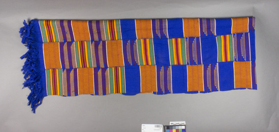 Hearst Museum object 4 of 4 titled Shawl, accession number 5-16697, described as Kente cloth shawl; 5 narrow strips sewn together to form a shawl with fringes on each end (blue). colors include golden yellow, green, dark red, royal blue, black and white. alternating patterns of basket like design, colored stripes and solid blue sections.