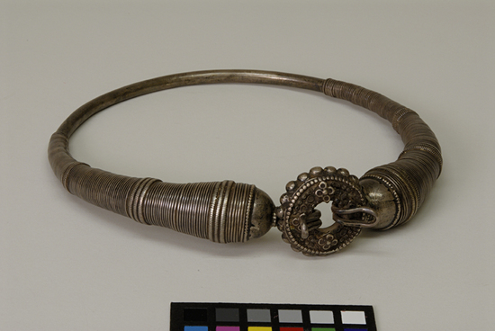 Hearst Museum object titled Neck ornament, accession number 9-11385, described as neck ornament; 'hansli' (torque); silver; circular hoop, partially wound around with silver wire; closes in front with a hook through a medallion; Diameter 21.5 cm.