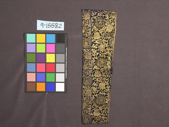 Hearst Museum object titled Textile, accession number 9-15582, described as Lined piece; silk, flat gilt paper strips, cotton lining; satin, brocaded, plain weave lining; dark blue ground, gold designs, light brown lining; dragon, floral motives; 6 in. x 22 in.