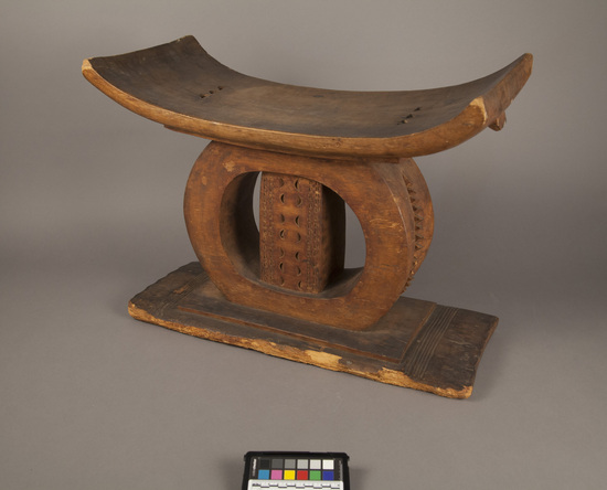 Hearst Museum object titled Stool (seating furniture), accession number 5-3449, described as Carved wooden stool. Asantehene design? Curved seat supported by oval with bar in centrer.