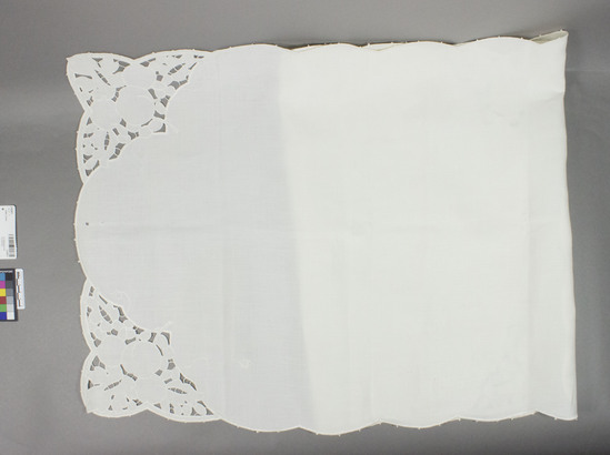 Hearst Museum object titled Table cover, accession number 2-62831, described as Dresser Scarf: White linen strip embroidered in white button hole stitch. Edges embroidered in large scallops with spaced picots. Made in 1902 for Mr. Houts by his mother. ten large and small holes.