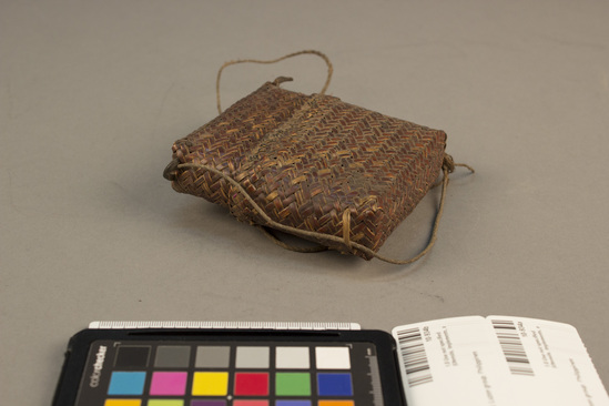 Hearst Museum object titled Basketry container, accession number 10-934a,b, described as Small envelope basketry pouch; twill plaiting, carrying cord