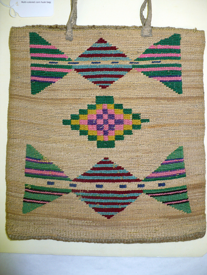 Hearst Museum object 8 of 8 titled Bag, accession number 2-22260, described as Multi-colored corn husk bag; cornhusk and wool overlay in plain twining; geometric designs in colored wool yarn on both faces; 2 rawhide thong handles.