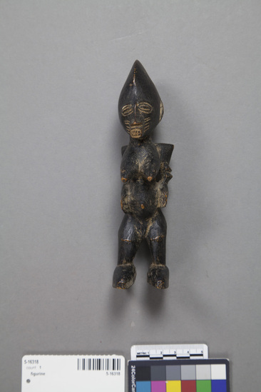 Hearst Museum object titled Figurine, accession number 5-16318, described as Female figure, carved wood, mask-like face, prominent breast and belly, thin arms with 2 arm bands around each, blocky feet, painted black overall. Conservation: Some paint worn on sides.