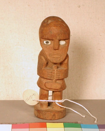 Hearst Museum object titled Figure, accession number 16-20454, described as Chimu style figure. Carved wooden figure, standing, holding long object with oblong bulb on end.  inlaid eyes.