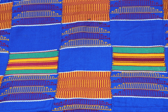 Hearst Museum object 2 of 4 titled Shawl, accession number 5-16697, described as Kente cloth shawl; 5 narrow strips sewn together to form a shawl with fringes on each end (blue). colors include golden yellow, green, dark red, royal blue, black and white. alternating patterns of basket like design, colored stripes and solid blue sections.