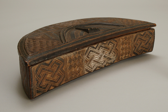 Hearst Museum object titled Box and lid, accession number 5-14072a,b, described as Black box with lid.  Wood, half circle shape, carved, all-over geometric design, stained black.  A-Box, B-Lid lg. - 33 1/2 cm., wd. - 15 cm., dp. - 6 1/2 cm.