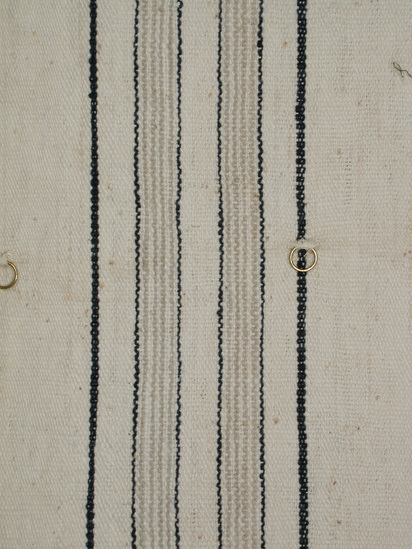 Hearst Museum object 3 of 4 titled Textile, accession number 5-16777, described as 1 panel tie dyed (indigo and white) fabric made into a curtain. design is made up of alternating bands of white and leaf patterns. Conservation: Brass rings at 37.5cm from finished end.