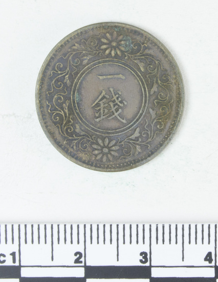 Hearst Museum object 2 of 4 titled Coin: copper 1 sen, accession number 9-6055, described as Coin; Cu; 1 Sen. Obverse: floral designs. Reverse: 1 Sen (in Japanese script)