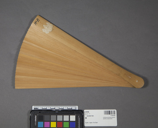 Hearst Museum object titled Fan, accession number 9-16183, described as Wooden fan (cypress) strung together with white silk thread. Fan has 25 ribs, on outside ribs there is a silk flower pasted at the top; fan is held together at the base with a silk cord.