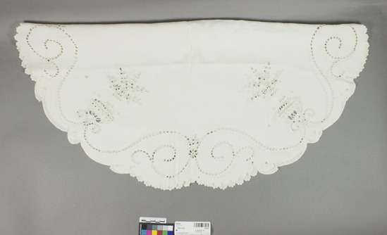 Hearst Museum object titled Table cover, accession number 2-62834, described as Circle of white linen embroidered in white. Plain center surrounded by “Broderie Anglaise.” White embroidery.