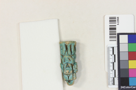 Hearst Museum object 5 of 11 titled Amulet (gods), accession number 6-22068, described as Four-sided amulet of blue faience, showing faience, showing Horus (two sides), Harpocrates, and Serket; length 56 mm.