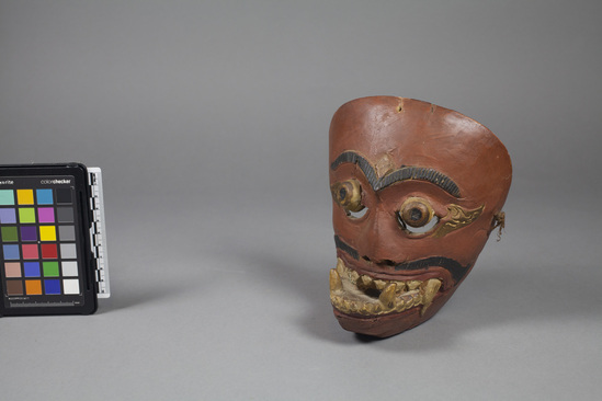 Hearst Museum object 3 of 4 titled Mask, accession number 18-1194, described as Mask, wood, carved and painted; jutting lower jaw and fang-like teeth; tan, gold, black and red. Used in dance. 18.0 cm.