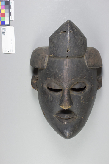 Hearst Museum object titled Mask, accession number 5-5962, described as Ibibo mask, ordinary, black. 3-part headdress, with pierced sides and top. H = 11.5”, W = 8.0”. Collected at Ikot Ekpene, Nigeria, in 1951.